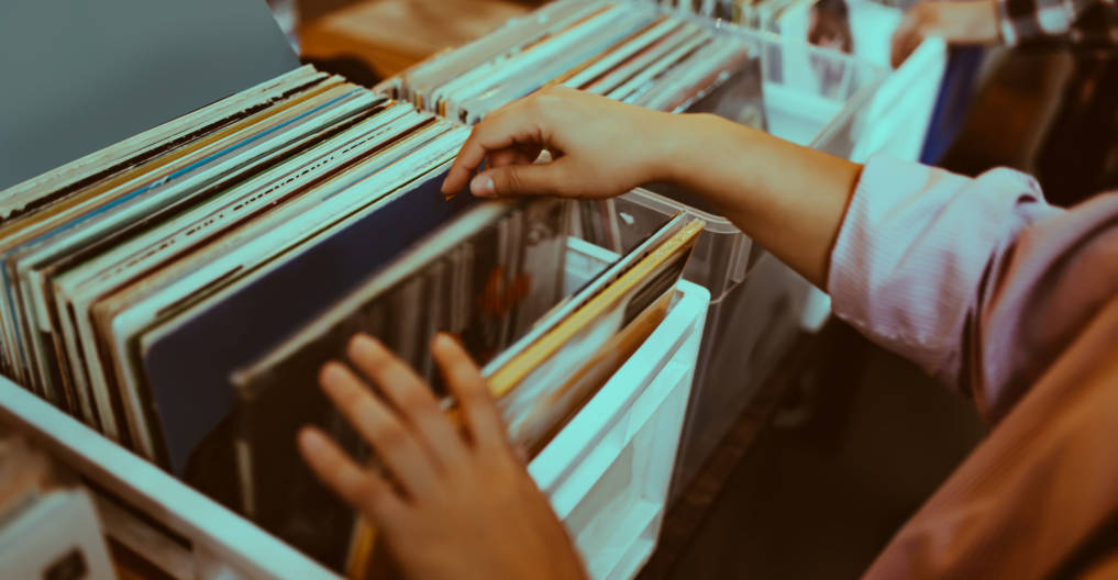 Woman is choosing a vinyl record in a musical store