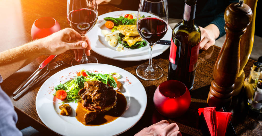 Couple having romantic dinner in a restaurant in rays of the sun