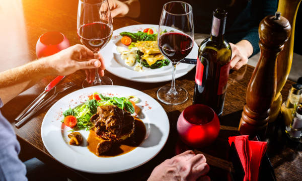 Couple having romantic dinner in a restaurant in rays of the sun