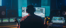 Artist, Musician, Audio Engineer, Producer in Music Record Studio, Uses Control Desk with Computer Screen showing Software UI with Song Playing. Success with Raised Hands, Dances. Back View.