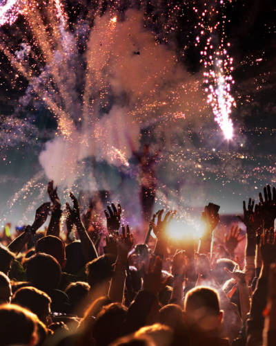 crowd with raised hands at concert festival banner