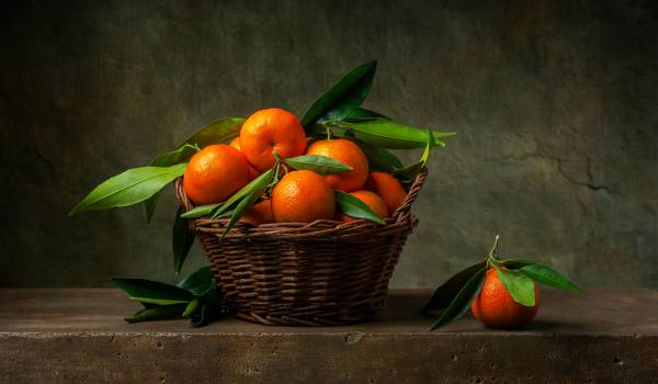 Still life with tangerines in a basket on the table