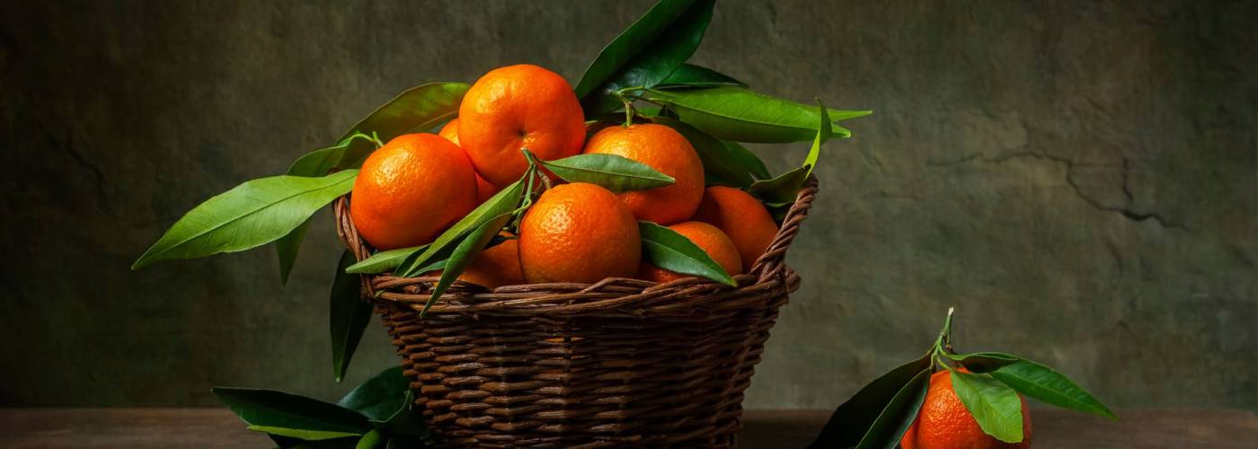 Still life with tangerines in a basket on the table