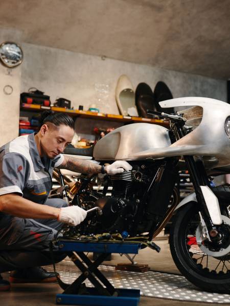 Repairman choosing tool when fixing motorcycle in his repairshop